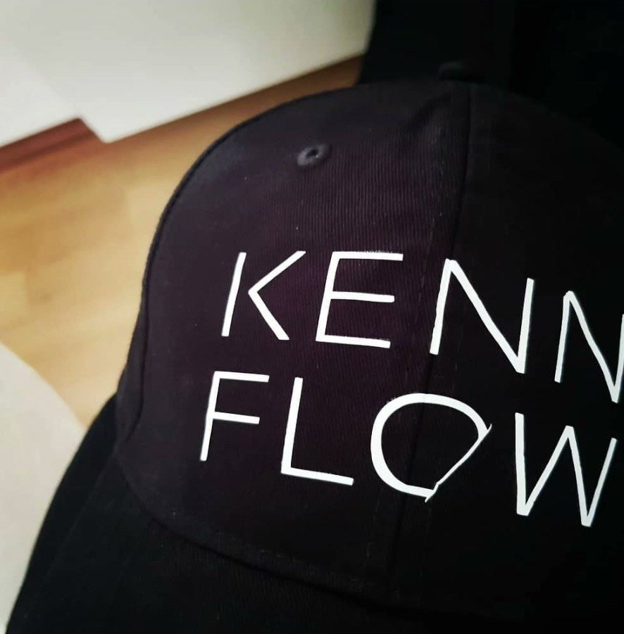Schwarze Cap mit dem weißen Aufdruck KENN FLOW