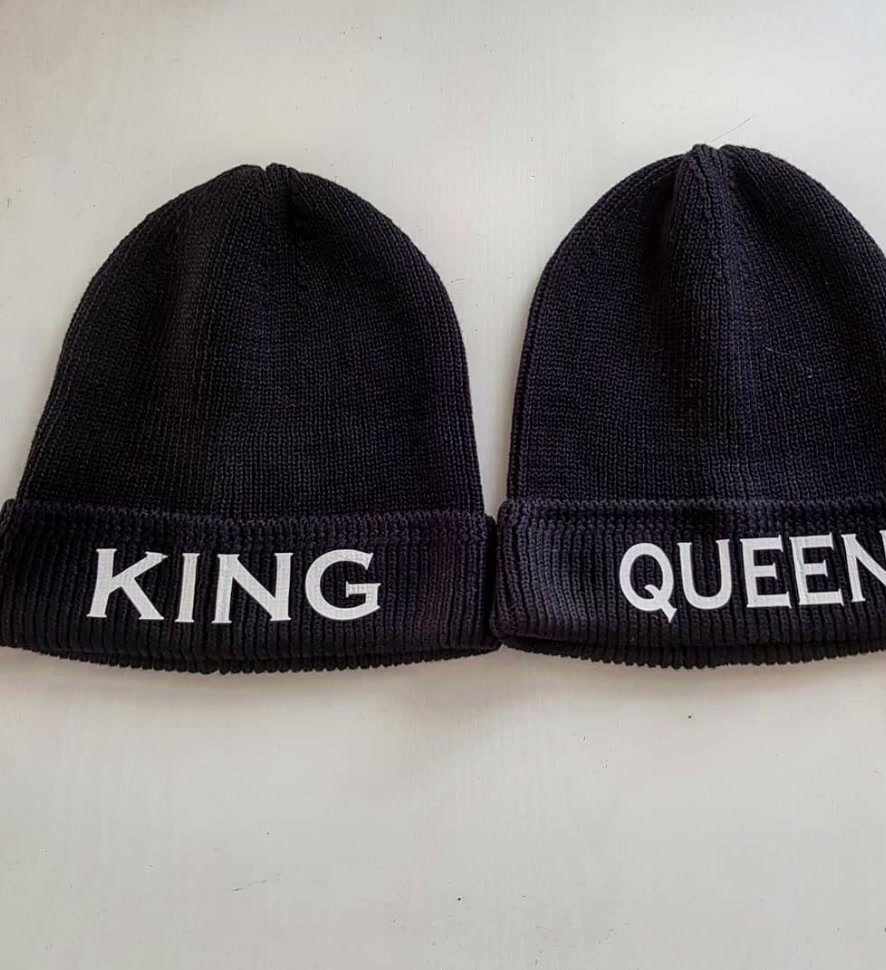 Zwei dunkle Strickmützen mit den Aufschriften KING und QUEEN