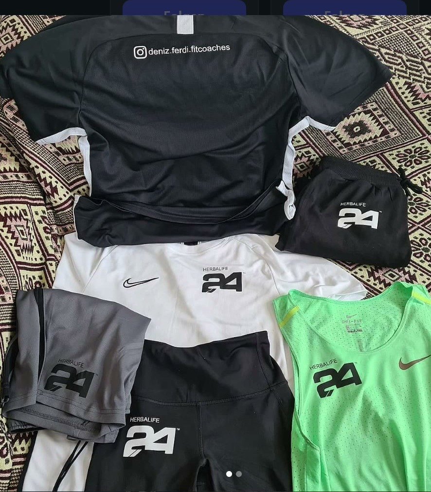 Mehrere Sportshirts und eine Hose in verschiedenen Farben mit dem gleichen Logo